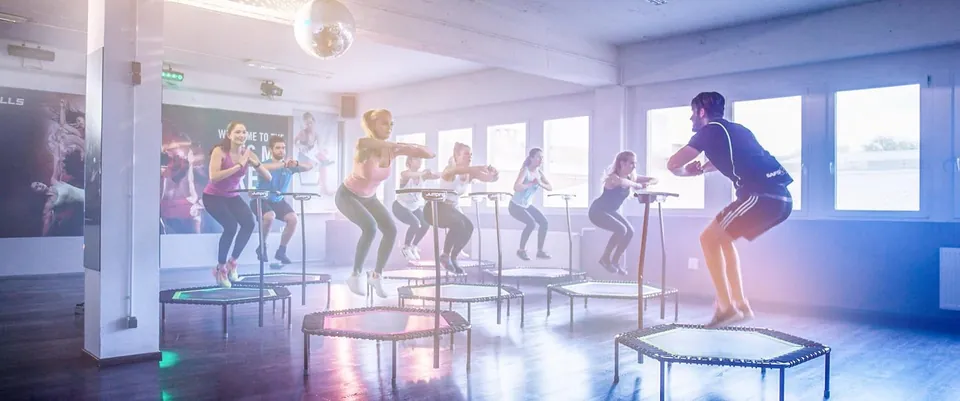 Kursteilnehmer springen auf Trampolinen im Cleverfit Studio in Saarbrücken, Szene aus dem Fitnessfilm